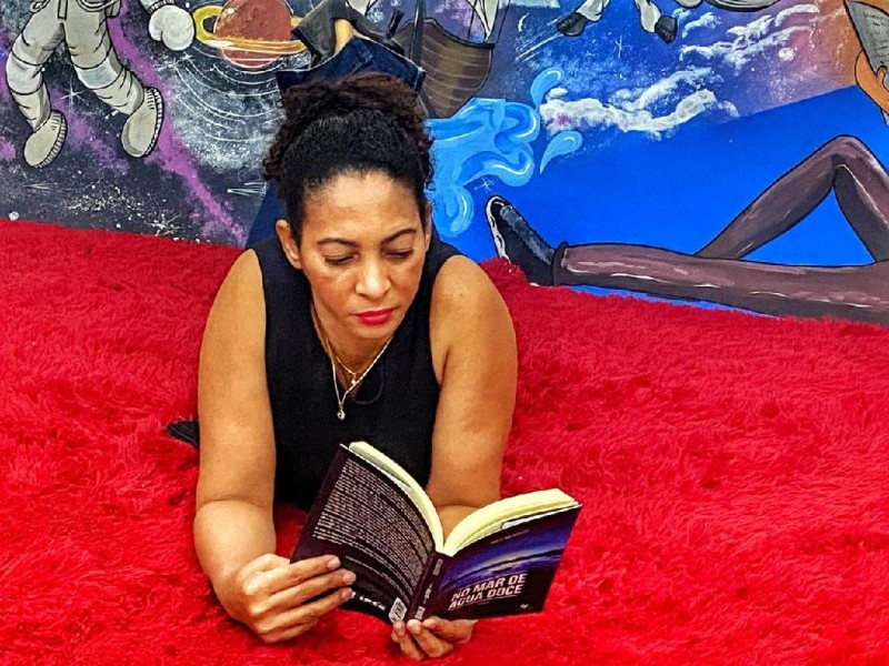 A idealizadora do projeto, Helena Maria, mostrando que para ler não importa o local - Foto por: Divulgação