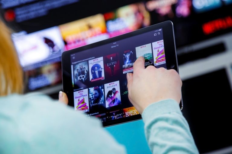 Mulher olha tablet com opção de filmes em streaming - (Foto: Depositphotos)